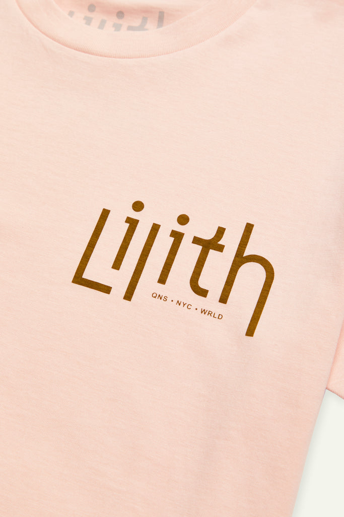A light pink crewneck t-shirt with the Lilith NYC wordmark logo screen printed on the upper left chest area. The logo color is moss.