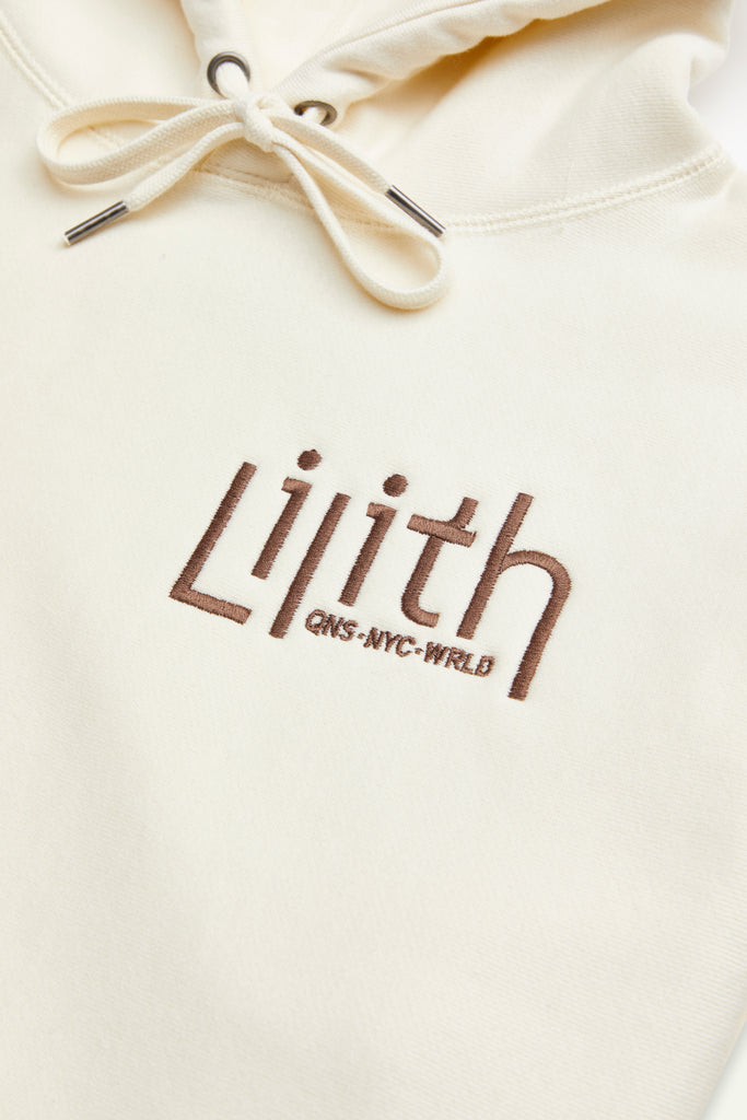 A cream or off-white hoodie with the Lilith NYC wordmark logo embroidered on the upper left chest area. Embroidery of a snake with a branch tail is located on the right side of the kangaroo pocket. All embroidery is in brown or dark chocolate.