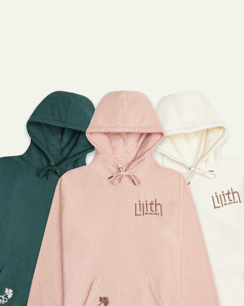 Jungle green, dusty pink, and cream-colored hoodies pictured here as a flat lay.