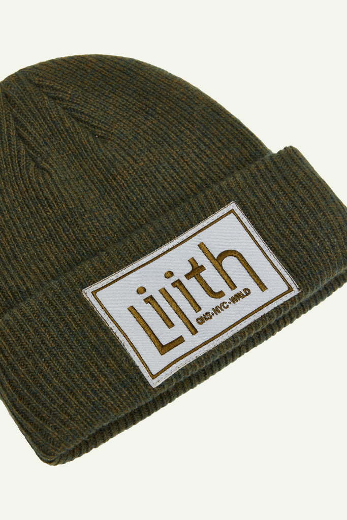 A green 100% merino wool beanie with a centered patch that includes the Lilith NYC wordmark in 2d embroidery. Embroidery is in a dark brown or moss colored thread.